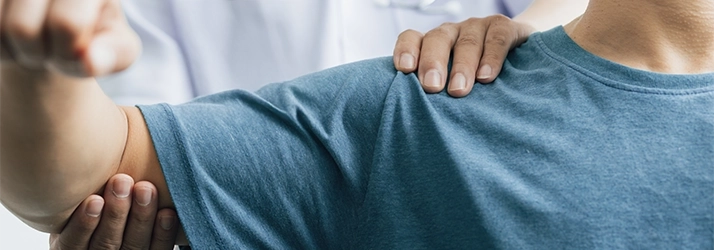 Chiropractic Quincy MA Arm Exam A person in a blue shirt receiving an arm exam.