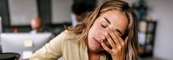 Chiropractic Quincy MA Woman Stressed A woman holding her forehead.